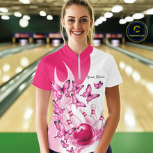 Load image into Gallery viewer, Female model wearing a white and pink bowling quarter zip with butterfly graphics and bowling artwork, front view at the bowling lane