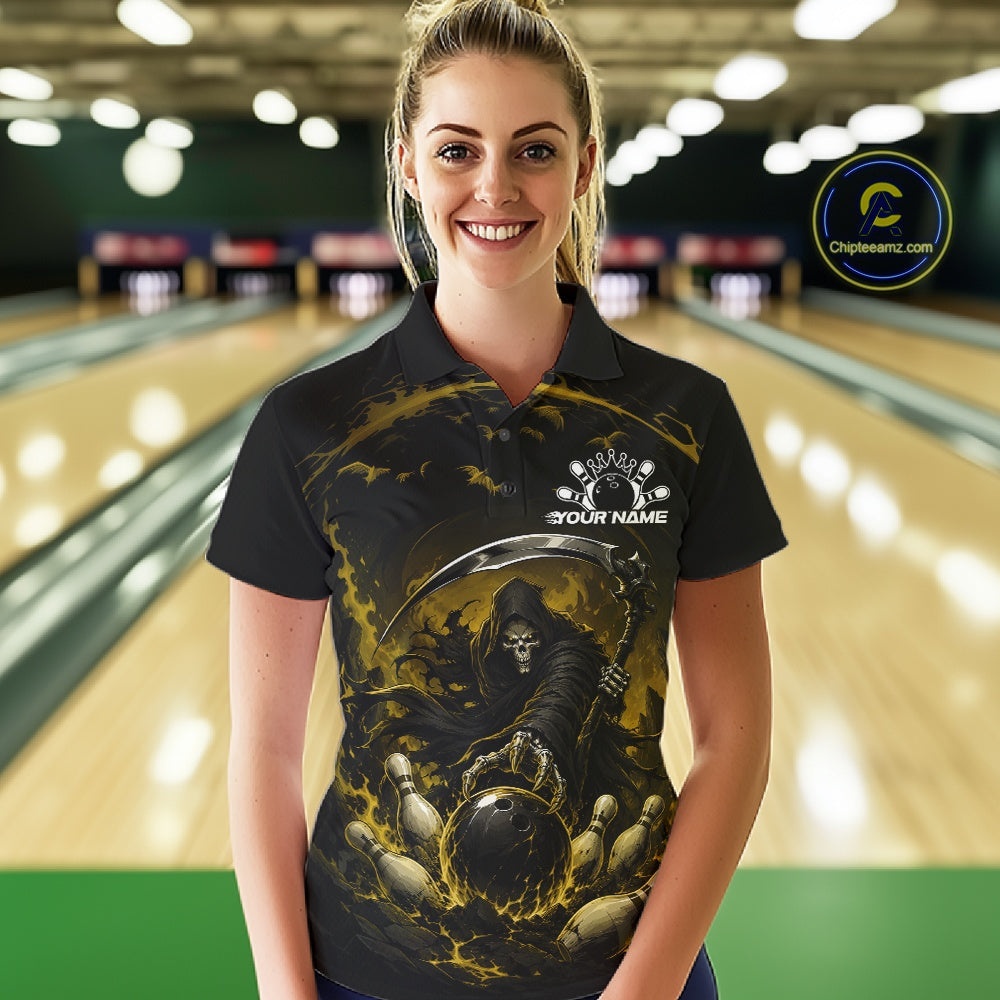 Front view of a female model wearing a black and yellow bowling polo shirt featuring a grim reaper commanding a blazing bowling ball crashing into scattered pins through swirling flames in a bowling lane.