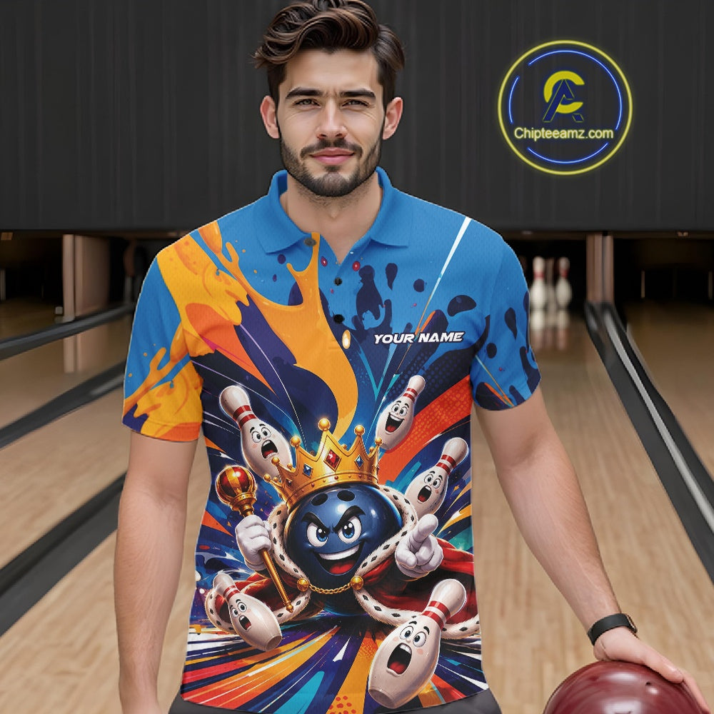 Front view of a male model wearing a bowling polo shirt showcasing a crowned cartoon bowling ball with a royal scepter, animated bowling pins, and colorful paint splash artwork in a bowling lane.