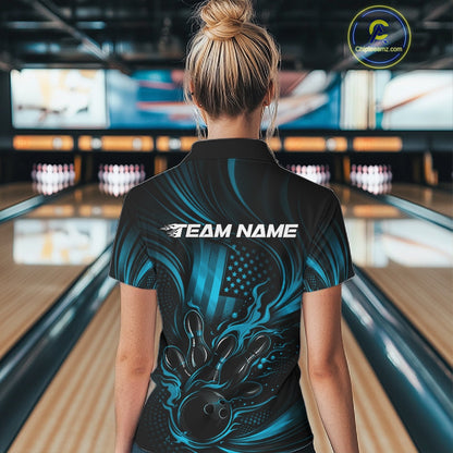 Back view of a female model in a bowling alley wearing a black and turquoise blue quarter-zip shirt featuring a patriotic flaming bowling ball striking pins over a distressed American flag.