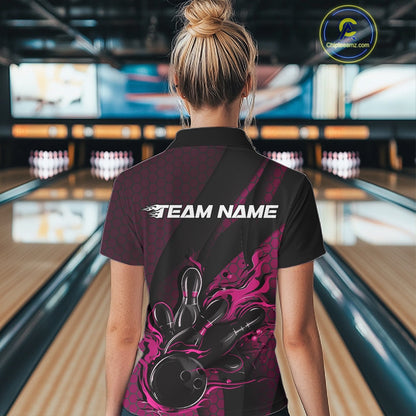 Female model inside a bowling center, back view of black and pink quarter zip shirt highlighting fiery bowling ball striking pins with abstract patterned details