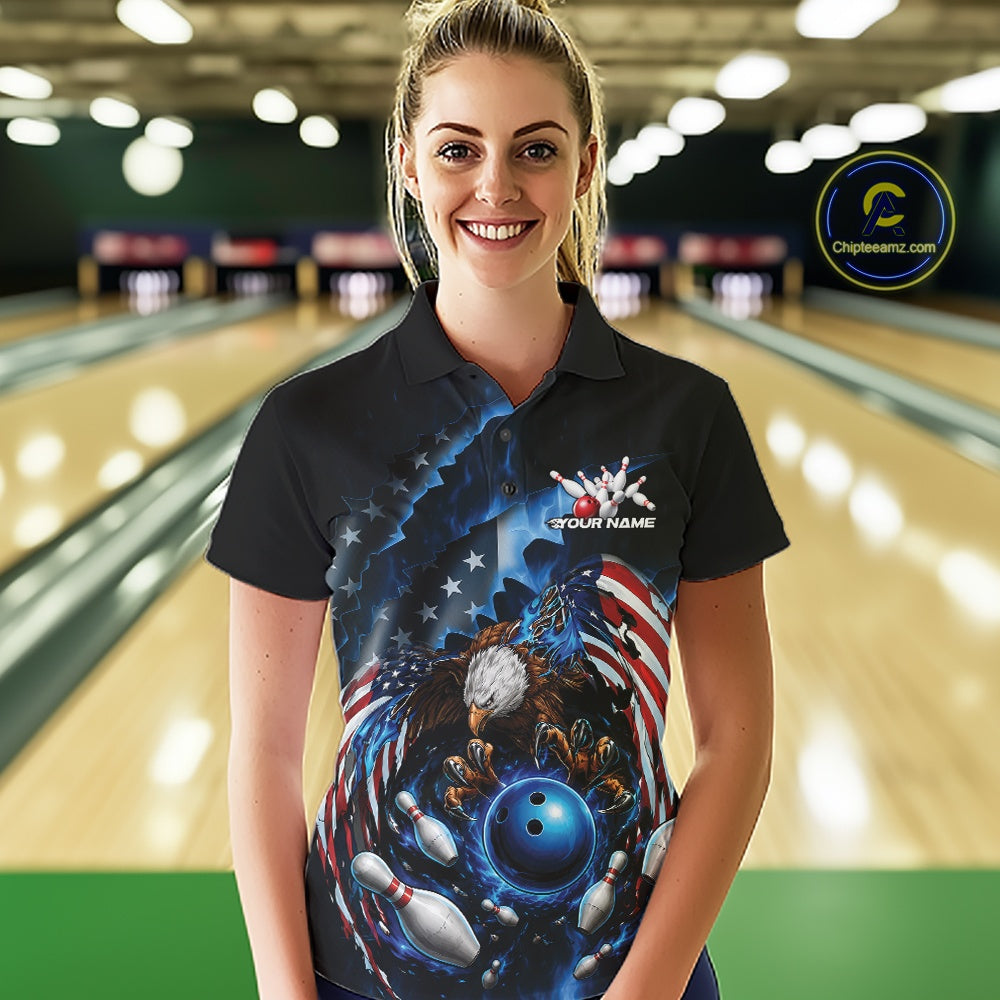 Front view female model at the bowling lane wearing a bowling polo shirt with bald eagle artwork, blue bowling ball, flying pins, and American flag background.