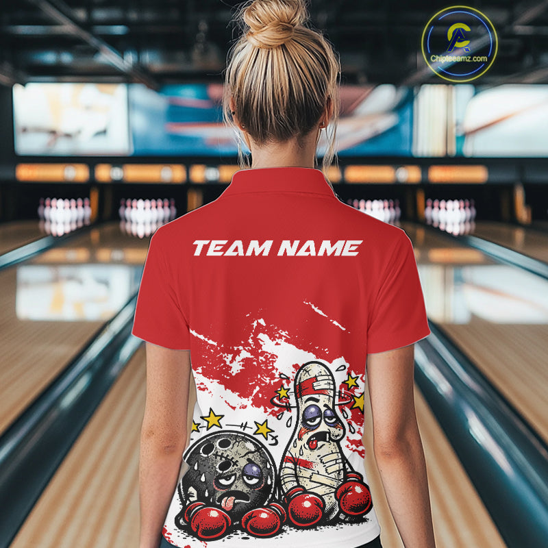 Back view of a female bowler in a red and white quarter-zip shirt, cartoon boxing bowling ball and pin artwork highlighted on back design.