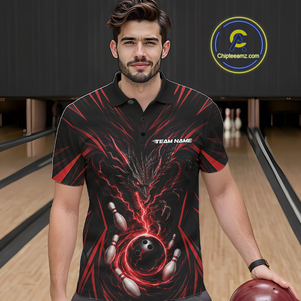 A man wearing a black short-sleeve polo shirt with a red and black bowling-themed graphic print, standing in a bowling alley holding a bowling ball. 