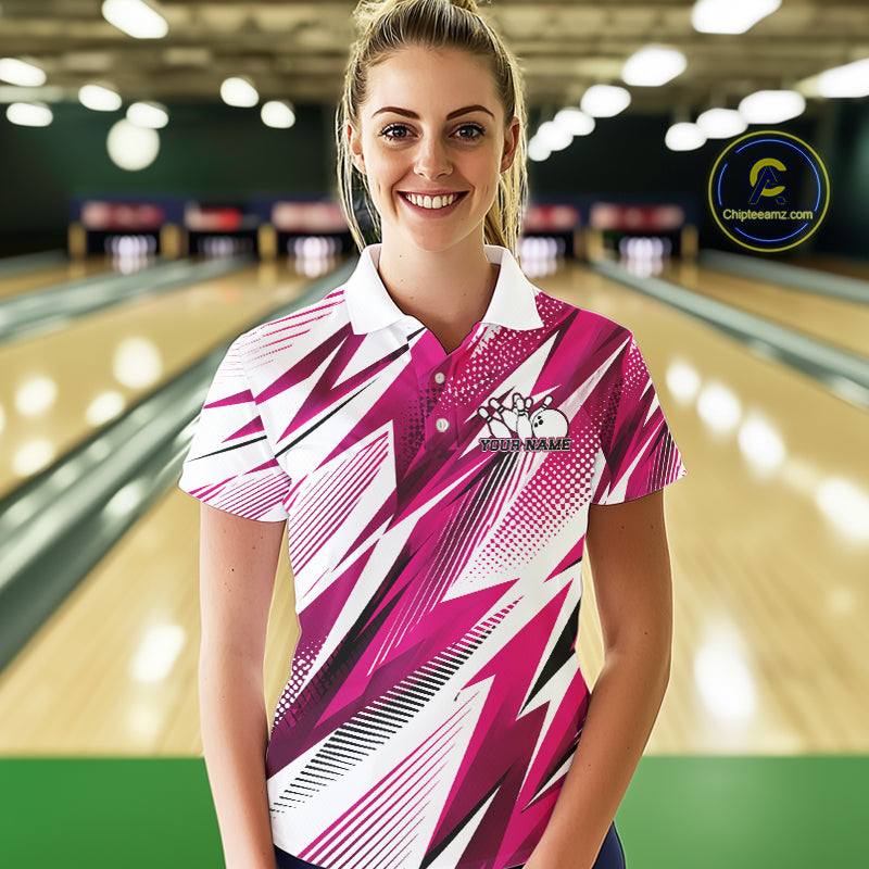 Woman wearing a pink and white bowling shirt with a logo in a bowling alley.