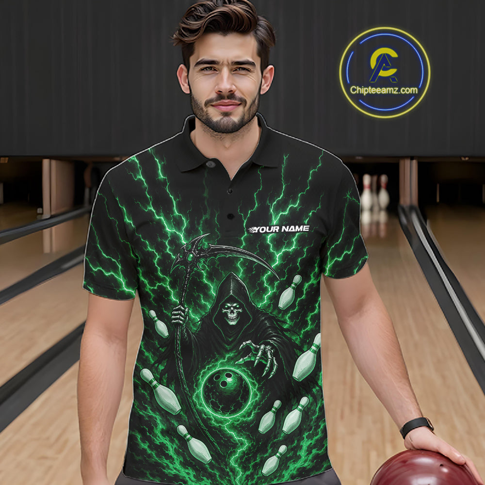 A man wearing a black short-sleeve polo shirt with a green grim reaper graphic and lightning design, standing in a bowling alley holding a bowling ball. 