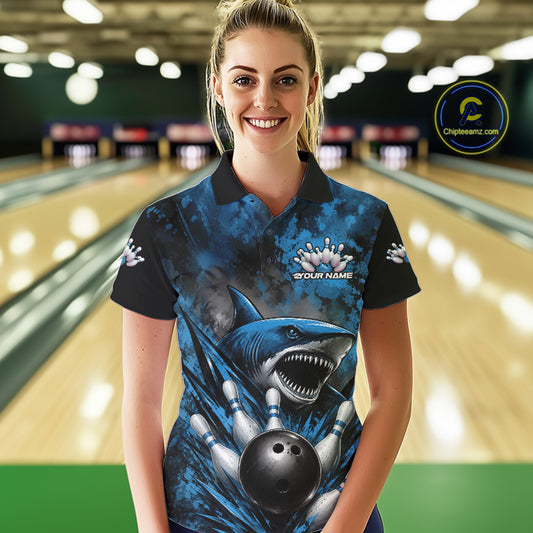 Woman wearing a blue and black bowling shirt with a shark design in a bowling alley.