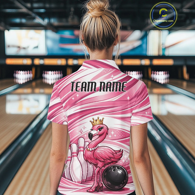 Back view of a female model in a bowling alley wearing a pink quarter-zip shirt showcasing a crowned flamingo beside bowling pins and a bowling ball.