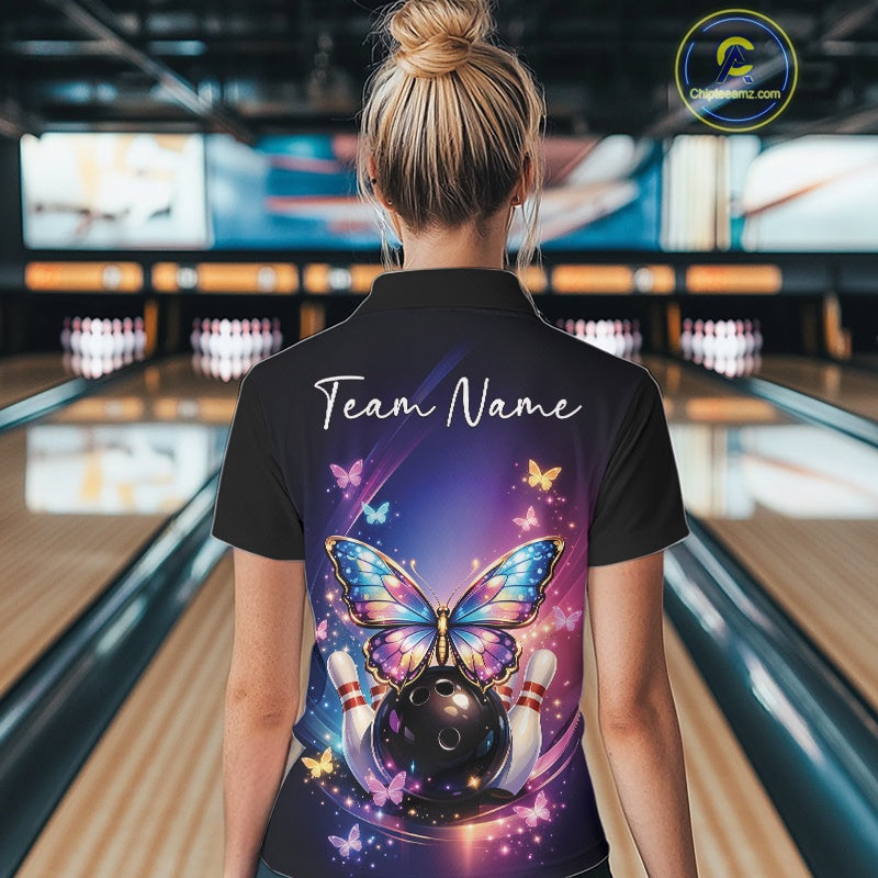 Back view of a female model in a bowling alley wearing a colorful quarter-zip shirt featuring glowing butterflies and fallen bowling pins.