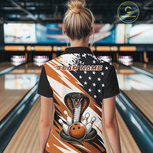 Load image into Gallery viewer, Back view of a woman in a bowling alley wearing a black, white, and orange american flag cobra-themed shirt with “Team Name” across the shoulders.