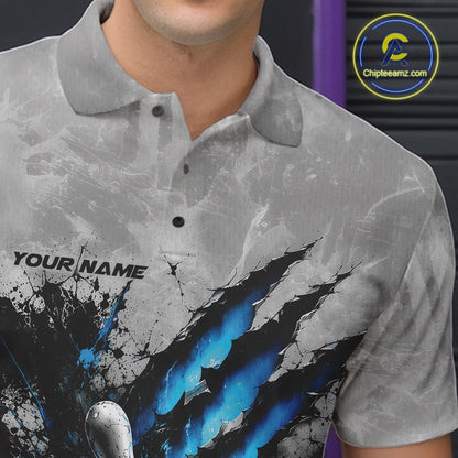Close-up view of the left chest of a gray bowling polo shirt featuring a dramatic blue bowling ball and pins graphic with claw-mark artwork.
