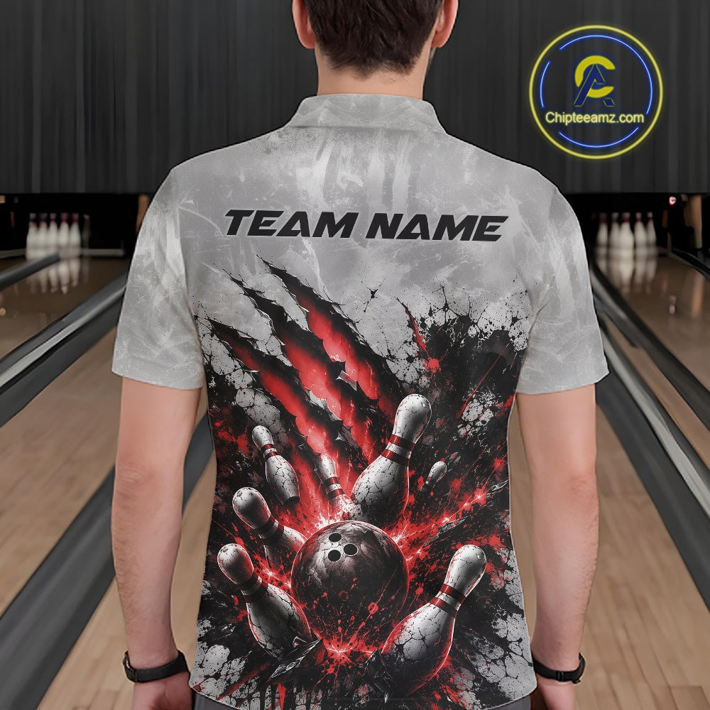 Back view of a male model wearing a gray bowling polo shirt with a dramatic red bowling ball and pins graphic accented by claw-mark artwork in a bowling lane.