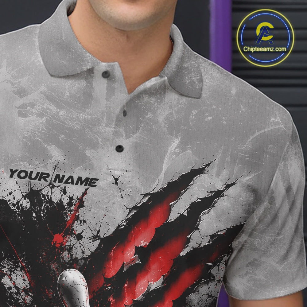 Close-up view of the left chest of a gray bowling polo shirt featuring a dramatic red bowling ball and pins graphic with claw-mark artwork.