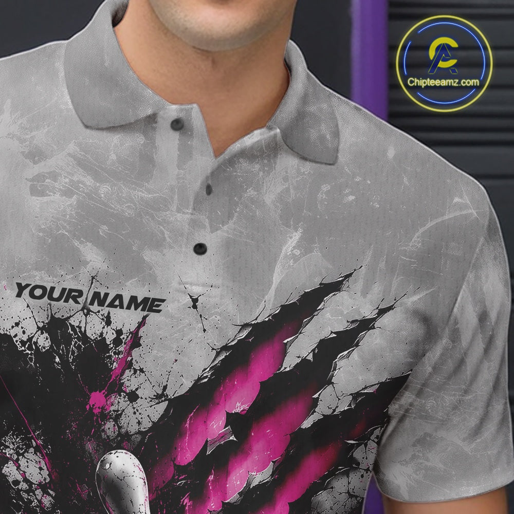 Close-up of the left chest on a gray bowling polo shirt featuring a dramatic pink bowling ball and pins graphic with claw-mark artwork.