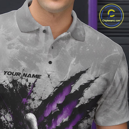 Close-up of the left chest on a gray bowling polo shirt featuring a dramatic purple bowling ball and pins graphic with claw-mark artwork.