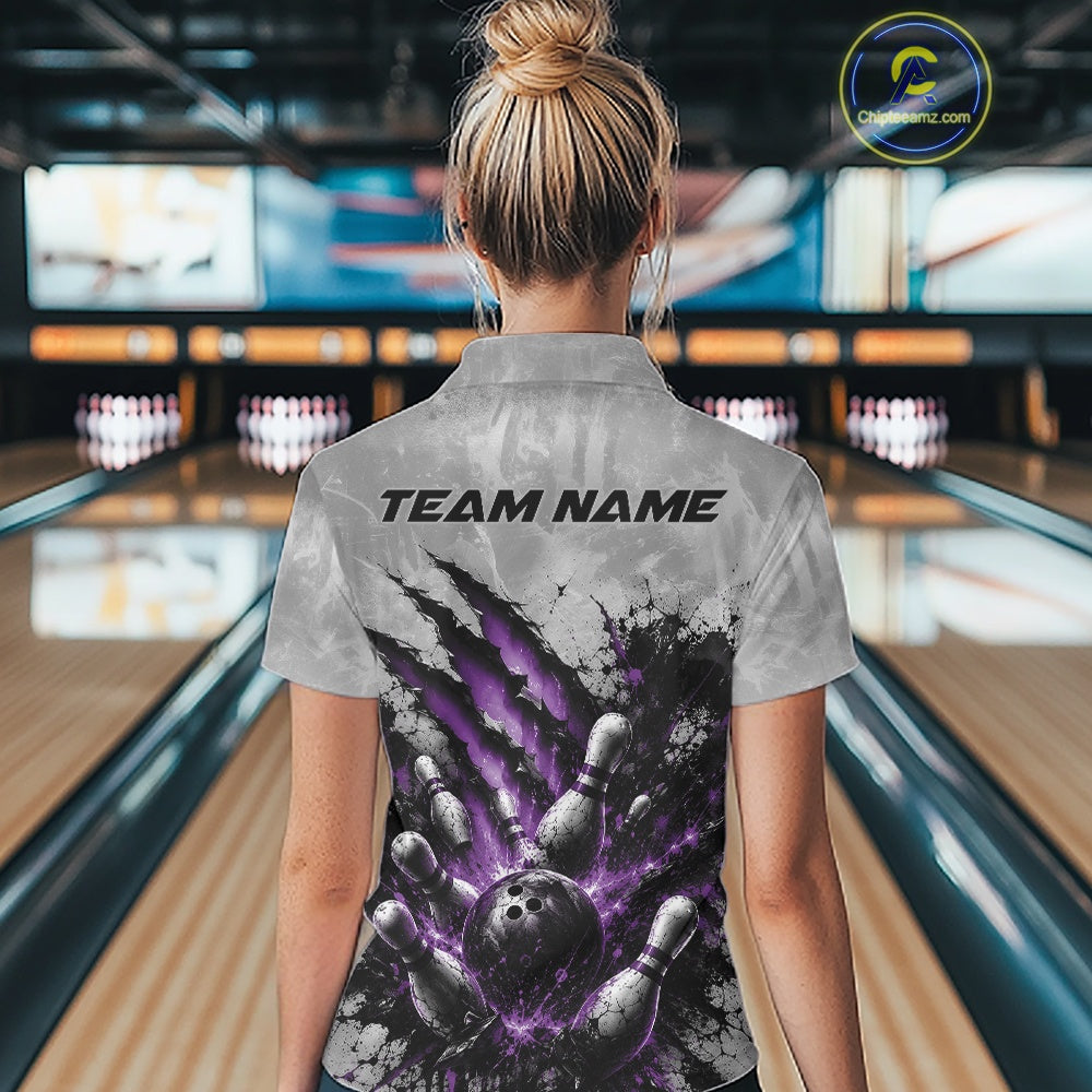 Back view of a female model wearing a gray bowling polo shirt showcasing a dramatic purple bowling ball and pins graphic with claw-mark artwork in a bowling lane.