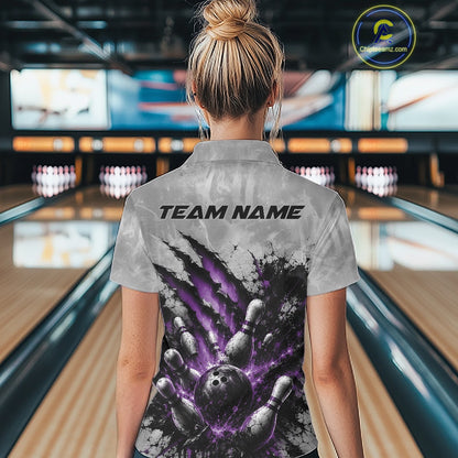 Back view of a female model wearing a gray bowling polo shirt showcasing a dramatic purple bowling ball and pins graphic with claw-mark artwork in a bowling lane.