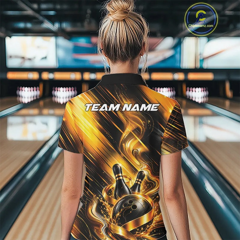 Back view of a female model wearing a bowling polo shirt showcasing a black and gold bowling ball hitting the pins graphic with flowing metallic ribbon accents in a bowling lane.