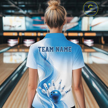 Load image into Gallery viewer, Female model standing in a bowling lane showing the back of a white and blue bowling quarter-zip shirt with abstract wave lines and a glossy bowling ball striking pins graphic.