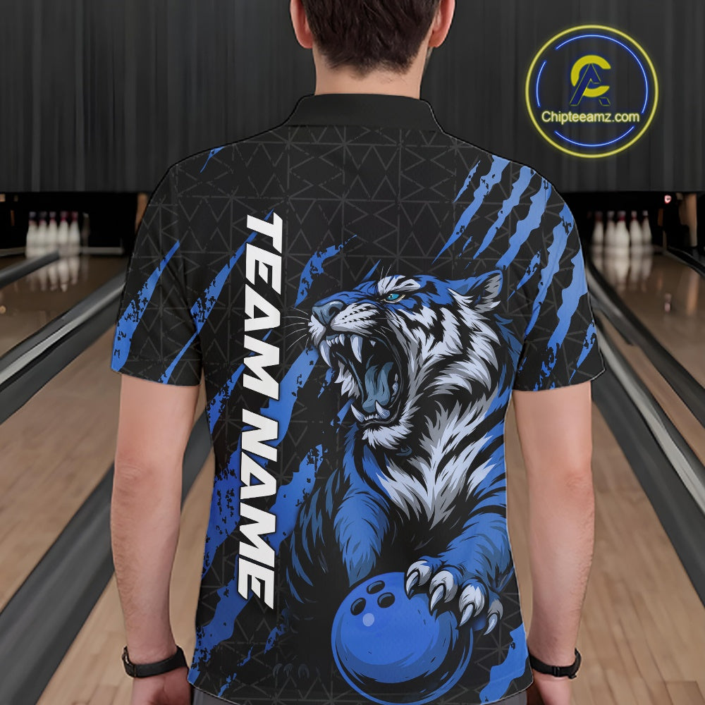 Back view of a male model in a bowling lane wearing a black and mid blue bowling polo shirt featuring a roaring tiger holding a mid blue bowling ball with coordinated claw-stripe graphics and a geometric background pattern.