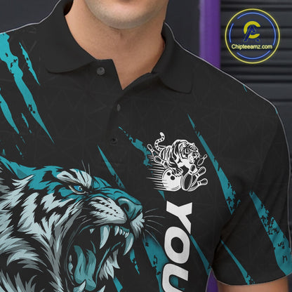Close-up view of the left chest on a black and teal blue bowling polo shirt showcasing a roaring tiger holding a teal blue bowling ball with teal blue claw-stripe artwork and a geometric background pattern.