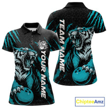 Load image into Gallery viewer, Front and back view of a black and teal blue women's bowling polo shirt featuring a roaring tiger holding a teal blue bowling ball with matching claw-stripe graphics and a geometric background pattern.