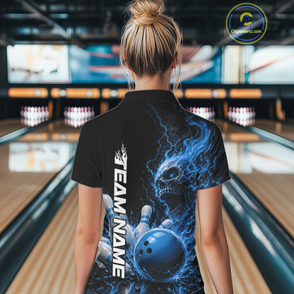 Back view of a female model in a bowling alley wearing a black bowling quarter zip shirt featuring a blue fiery skull with lightning striking a bowling ball and pins and a custom name.
