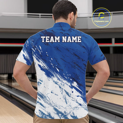 Front view of a male bowler in a bowling alley wearing a white and blue bowling quarter-zip shirt with a dynamic splatter sports jersey design