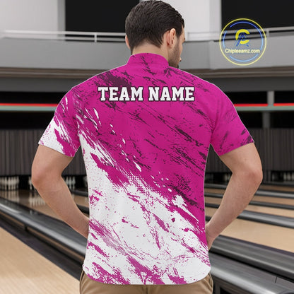 Person wearing a pink and white patterned shirt with 'TEAM NAME' text at a bowling alley.