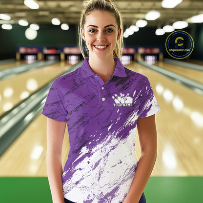 Woman wearing a purple and white bowling shirt with a logo in a bowling alley.