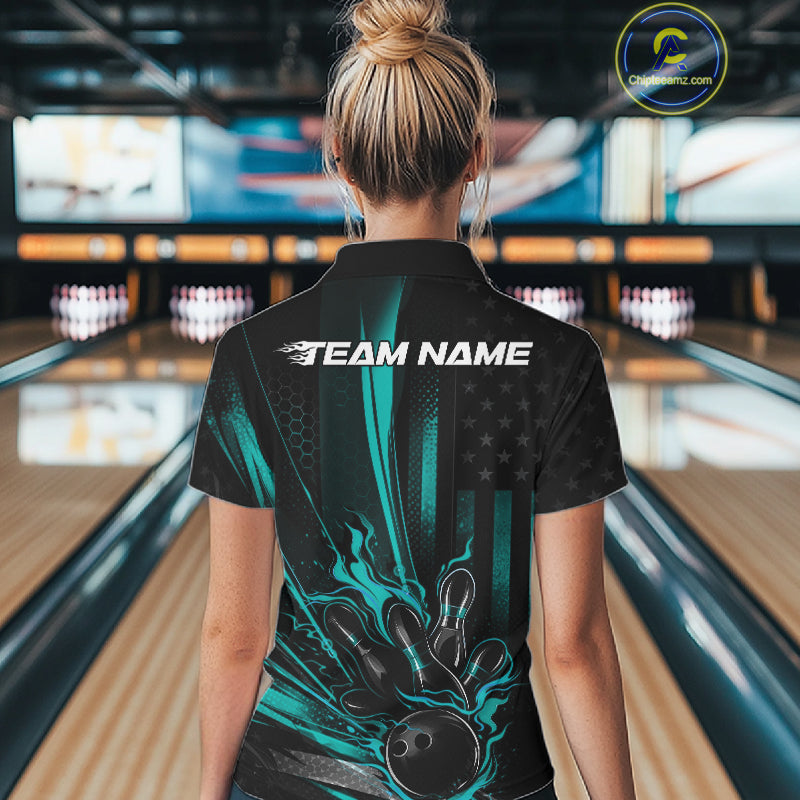 Back view of a female model in a bowling alley wearing a black and turquoise blue quarter-zip shirt showcasing a bowling ball and patriotic pin design.