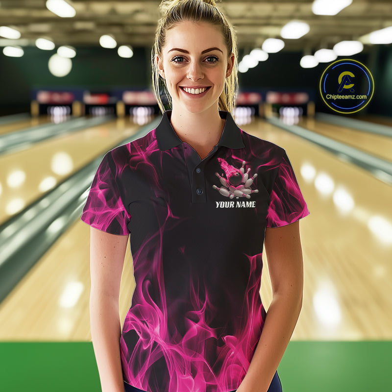 Female model wearing a black and pink bowling polo shirt at a bowling lane with dynamic bowling strike artwork, scattered pins, and fiery accents.