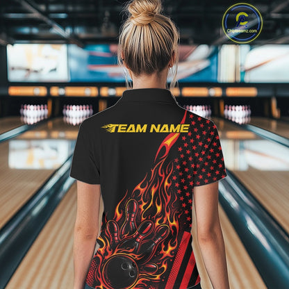 Back view of a female model in a bowling venue wearing a black quarter-zip shirt featuring fiery bowling pin graphics and patriotic accents.