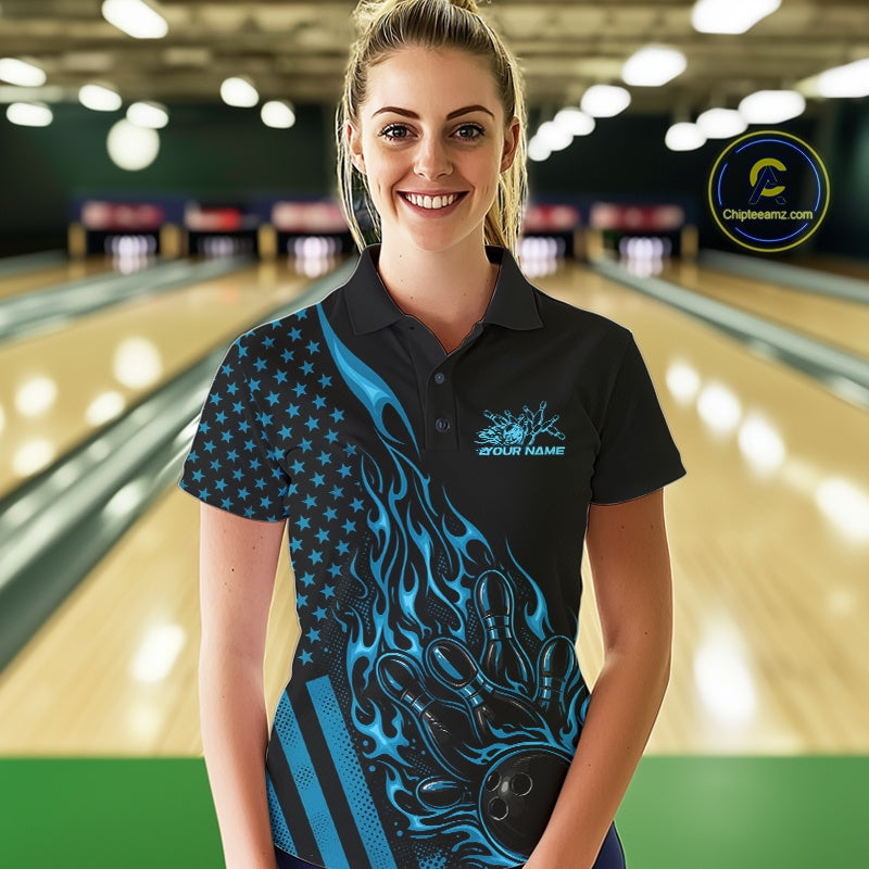 Female model wearing a black bowling polo shirt at a bowling lane with blue flame bowling strike artwork and patriotic details.