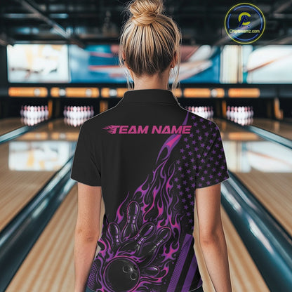 Back view of a female model in a bowling center wearing a black quarter-zip shirt showcasing a flaming bowling ball and patriotic pin graphics.
