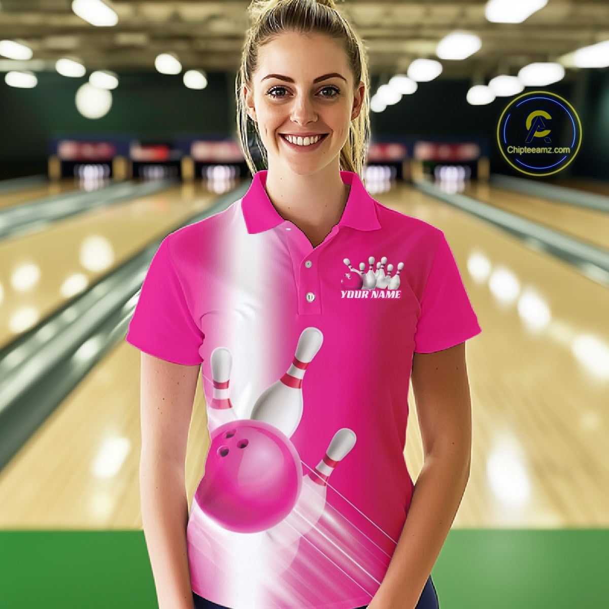Female model front view at the bowling lane wearing a bowling polo shirt with bowling ball and pins flowing through a pink gradient design.