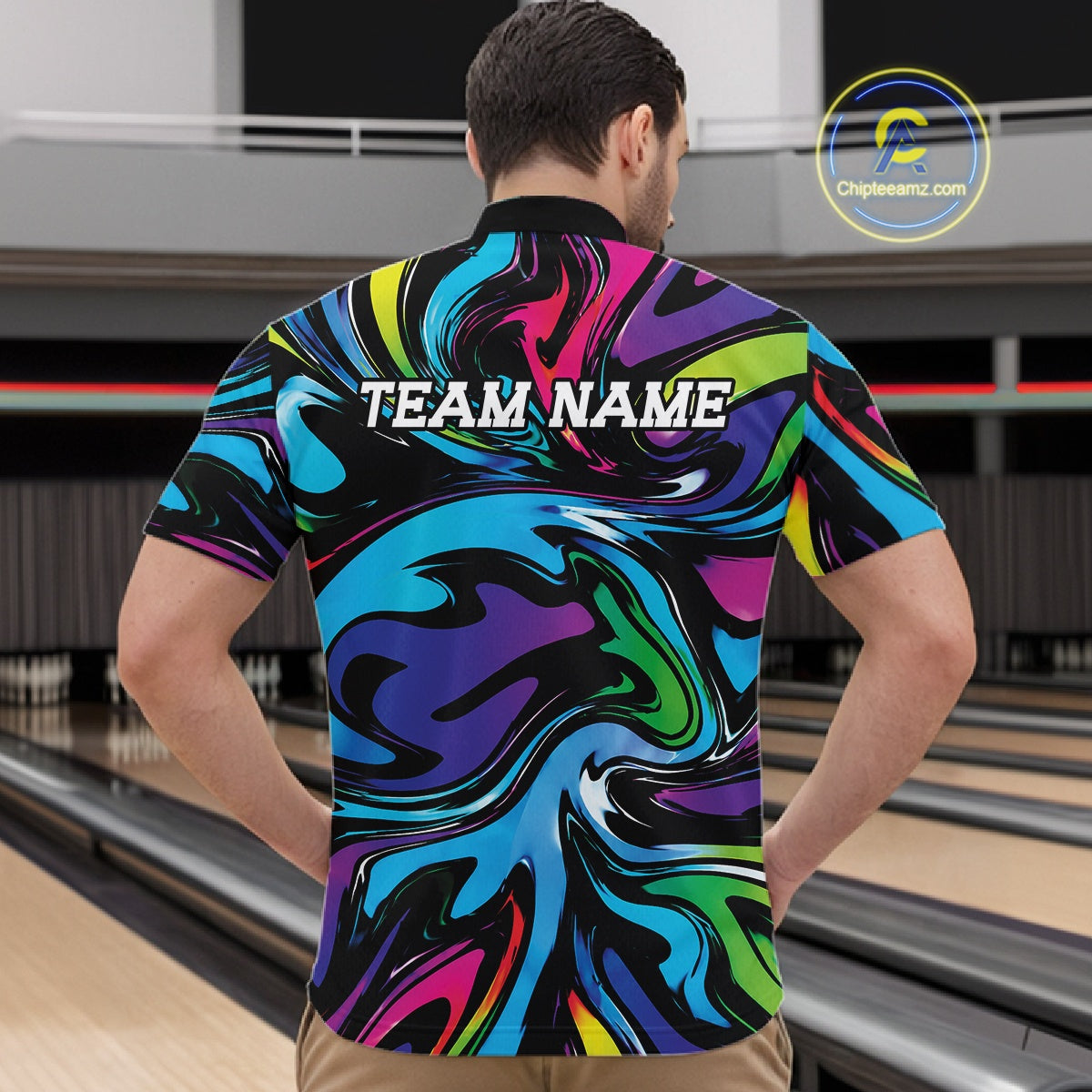 Man wearing a colorful shirt with 'TEAM NAME' text at a bowling alley.