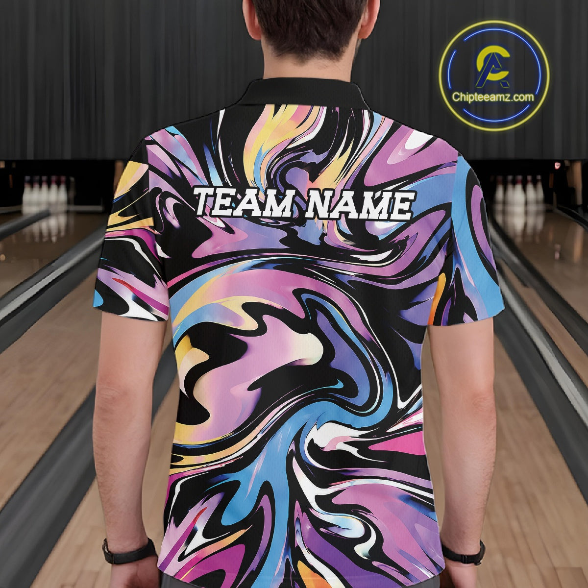 Person wearing a colorful 'TEAM NAME' shirt in a bowling alley.