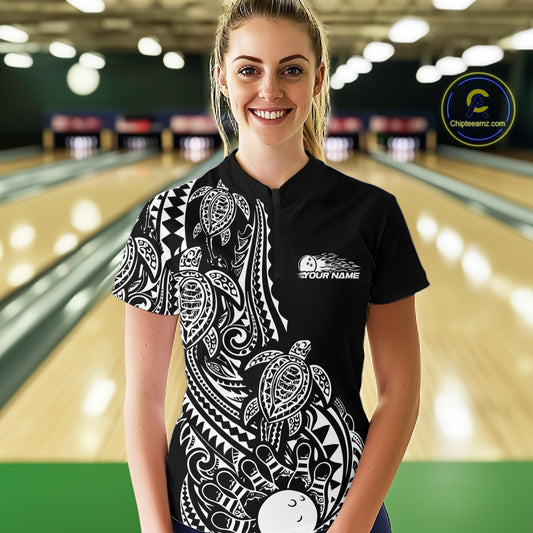 Female model wearing a black and white bowling quarter-zip shirt at the bowling lane with tribal swirl bowling graphics.