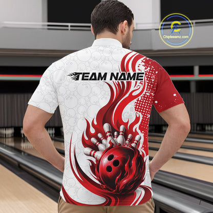 A man viewed from behind wearing a short-sleeve bowling shirt with a red and white flame-and-bowling-ball graphic, standing in a bowling alley. The shirt has 'TEAM NAME' printed across the upper back