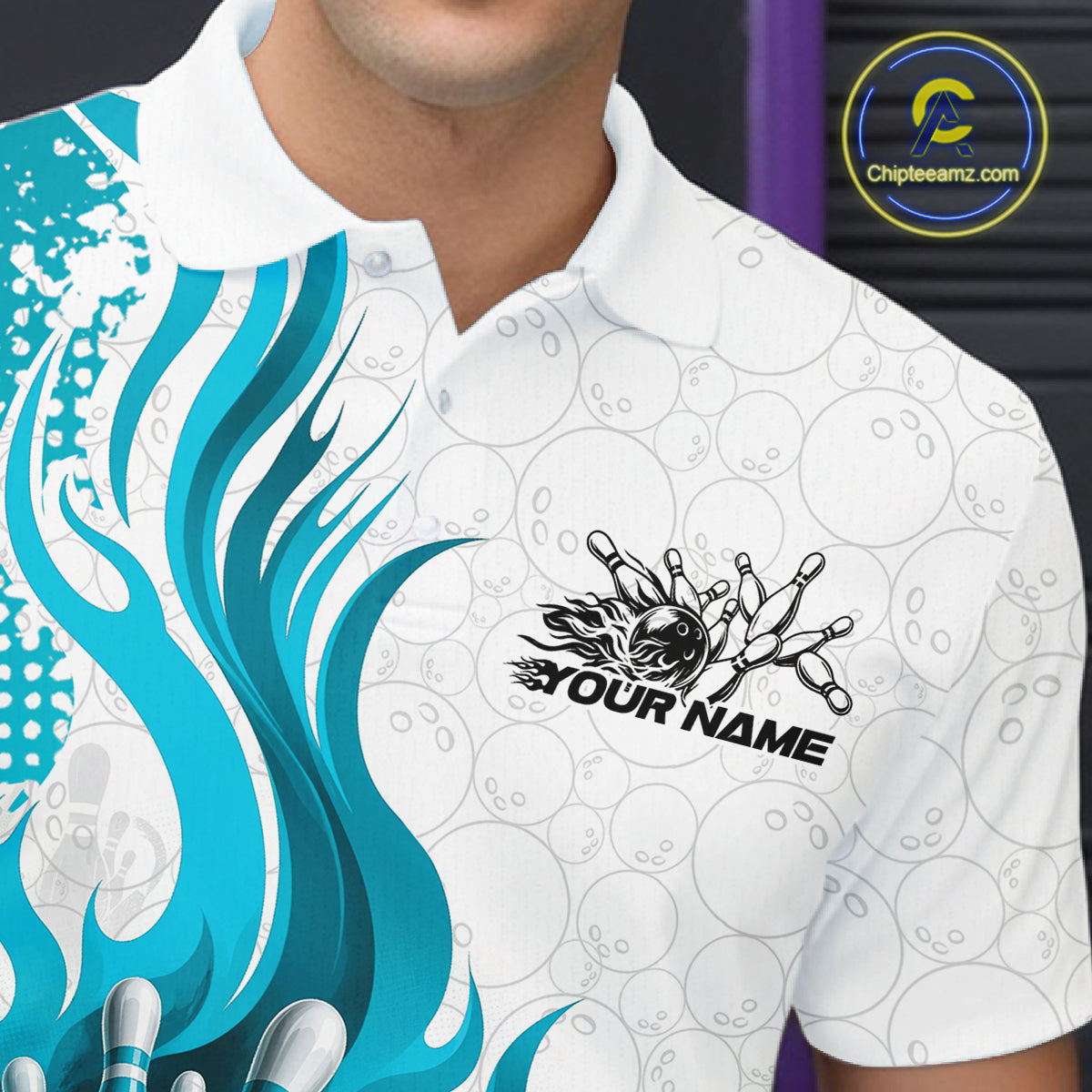 A close-up of a man wearing a white short-sleeve polo shirt with a bowling-themed graphic design. The shirt features a white base with a pattern of faint bowling pins and balls, a large bright blue and teal flame graphic on the left side, and a black bowling pin cluster graphic with the text 'YOUR NAME' on the right chest.