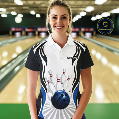 Front view of a female model wearing a white, black, and blue bowling polo shirt with bowling ball striking pins graphics in a bowling lane.