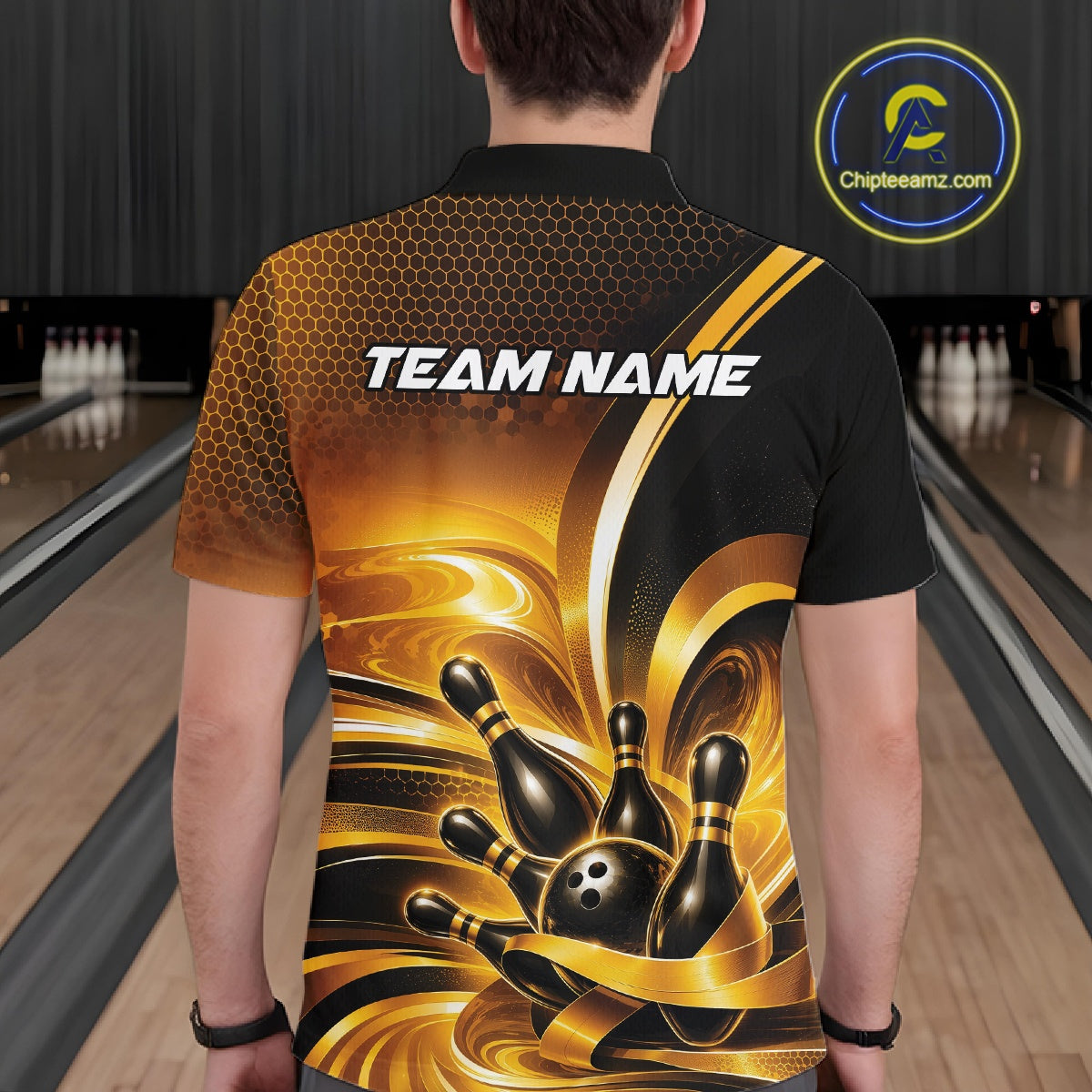 Back view of a male model in a bowling venue wearing a bowling polo shirt featuring glossy gold and black bowling ball and pins graphics.