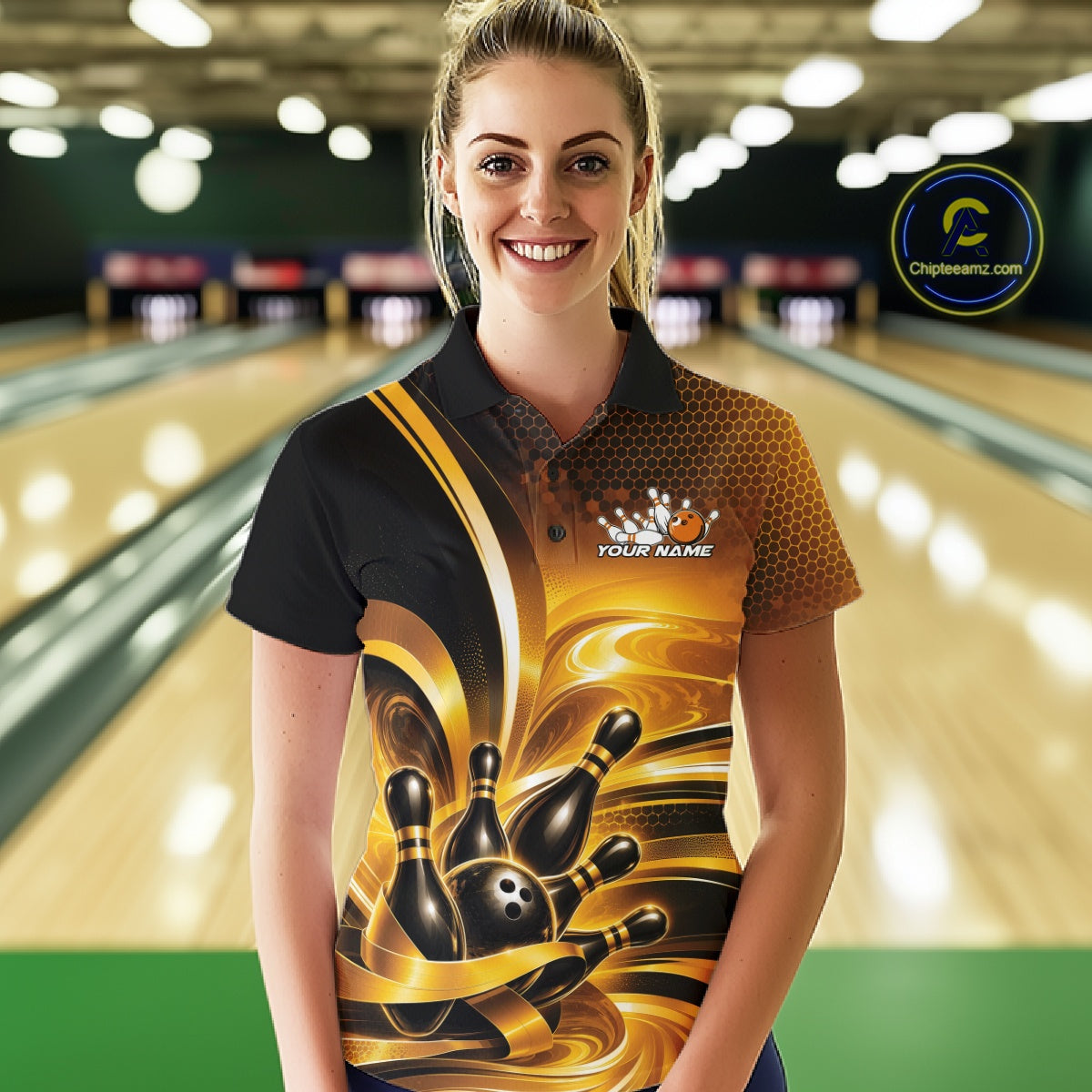 Front view of a female model inside a bowling center wearing a bowling polo shirt with glossy gold and black bowling ball and pins artwork.