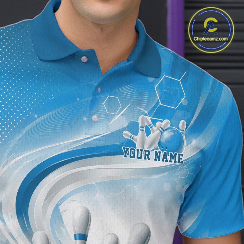 Close-up of the left chest on a white and blue bowling polo shirt showing abstract wave lines with a glossy bowling ball striking pins.