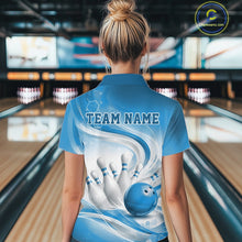 Load image into Gallery viewer, Female model standing in a bowling lane showing the back of a white and blue bowling quarter-zip shirt featuring abstract wave lines and a glossy bowling ball striking pins.