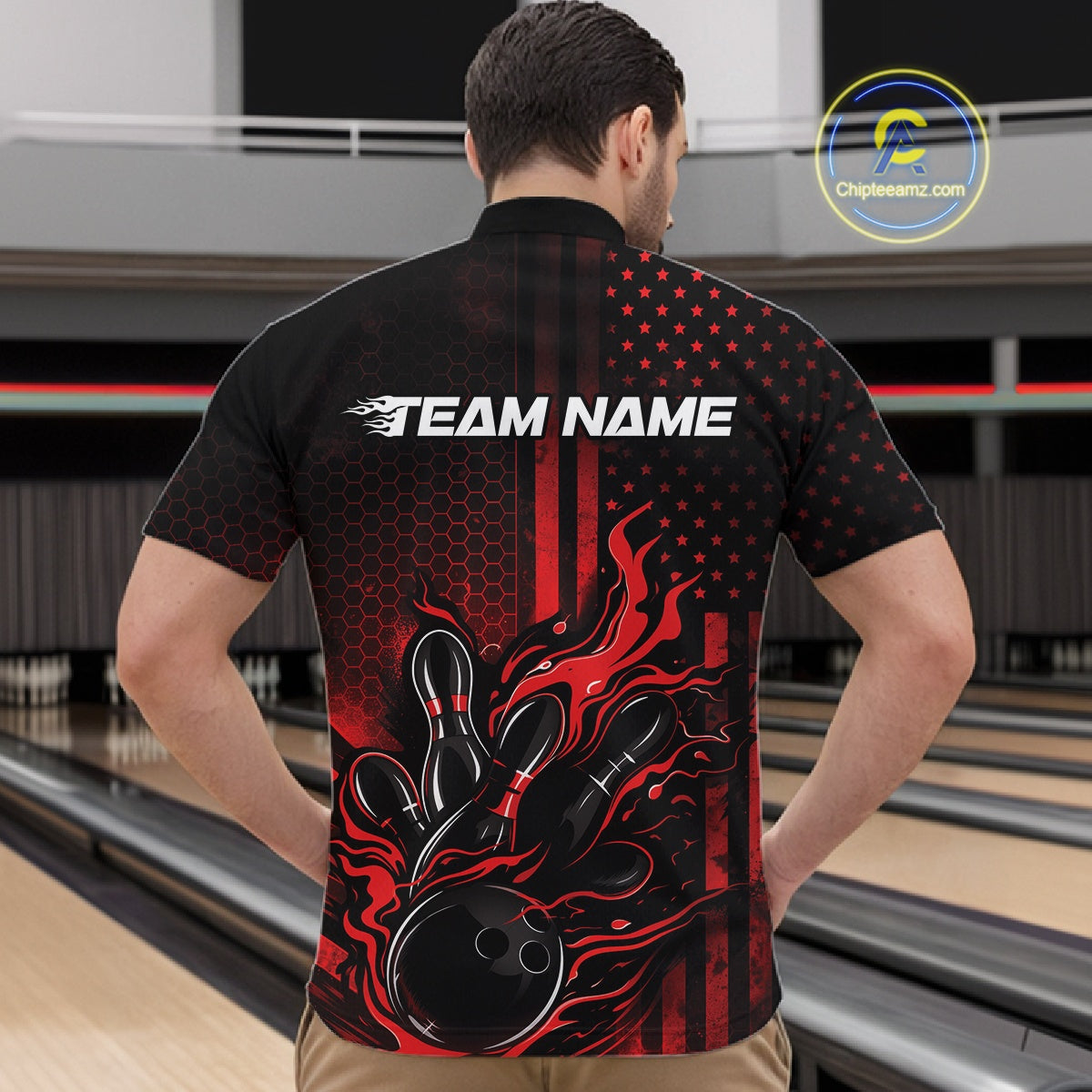 Front view of a male model in a bowling venue wearing a black and red quarter-zip shirt featuring a bowling strike motif with flame effects.