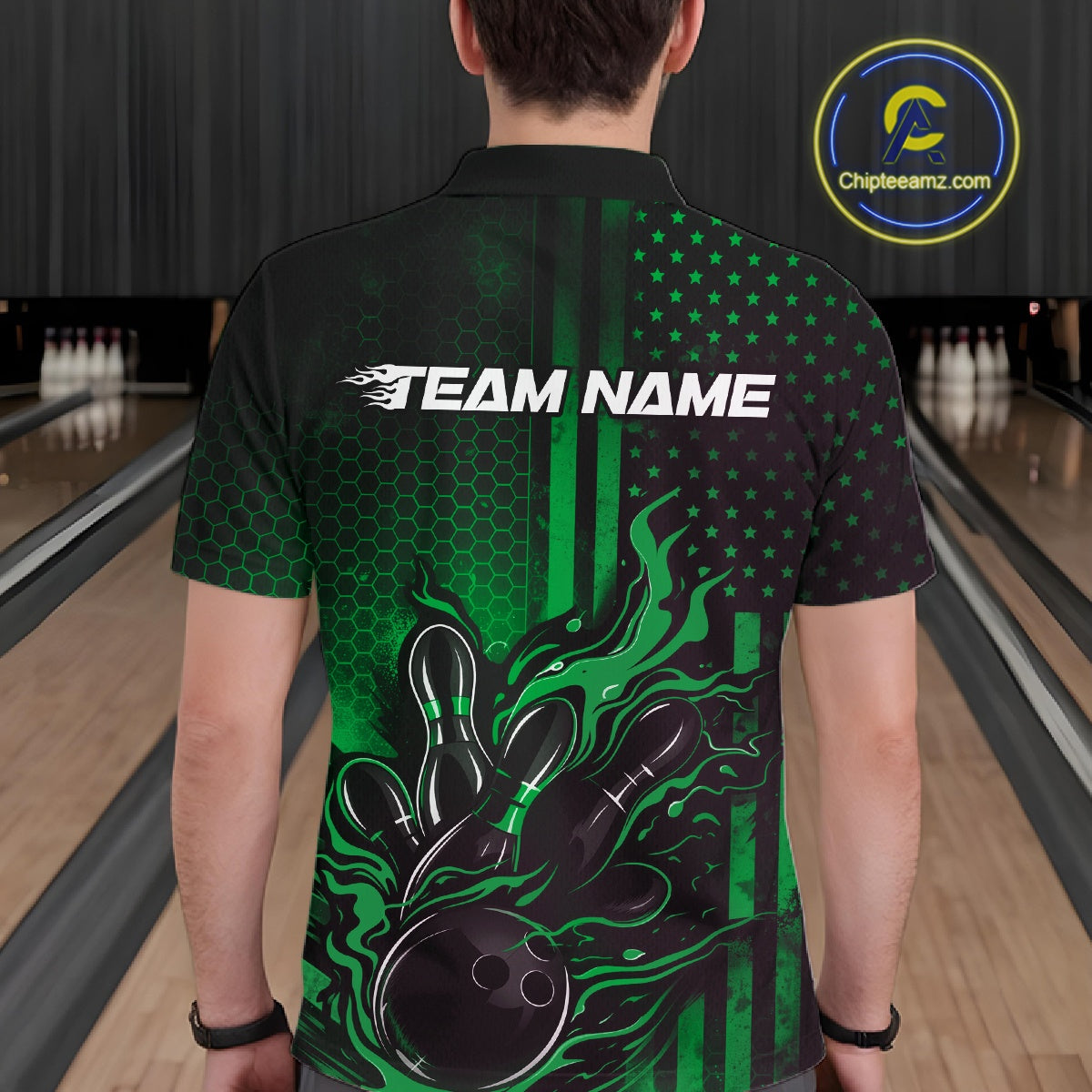 Back view of a male model in a bowling center wearing a black and green polo featuring flaming bowling ball and pin impact design.