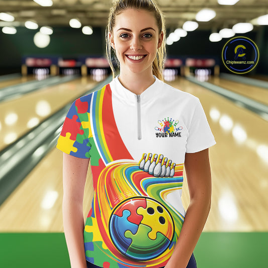 Female model in a bowling lane wearing a quarter-zip shirt, autism puzzle bowling lane artwork with bright multicolor design elements.