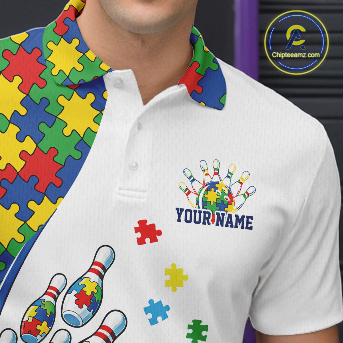 Close-up left chest detail of white bowling polo shirt showcasing colorful autism bowling strike emblem with puzzle accents